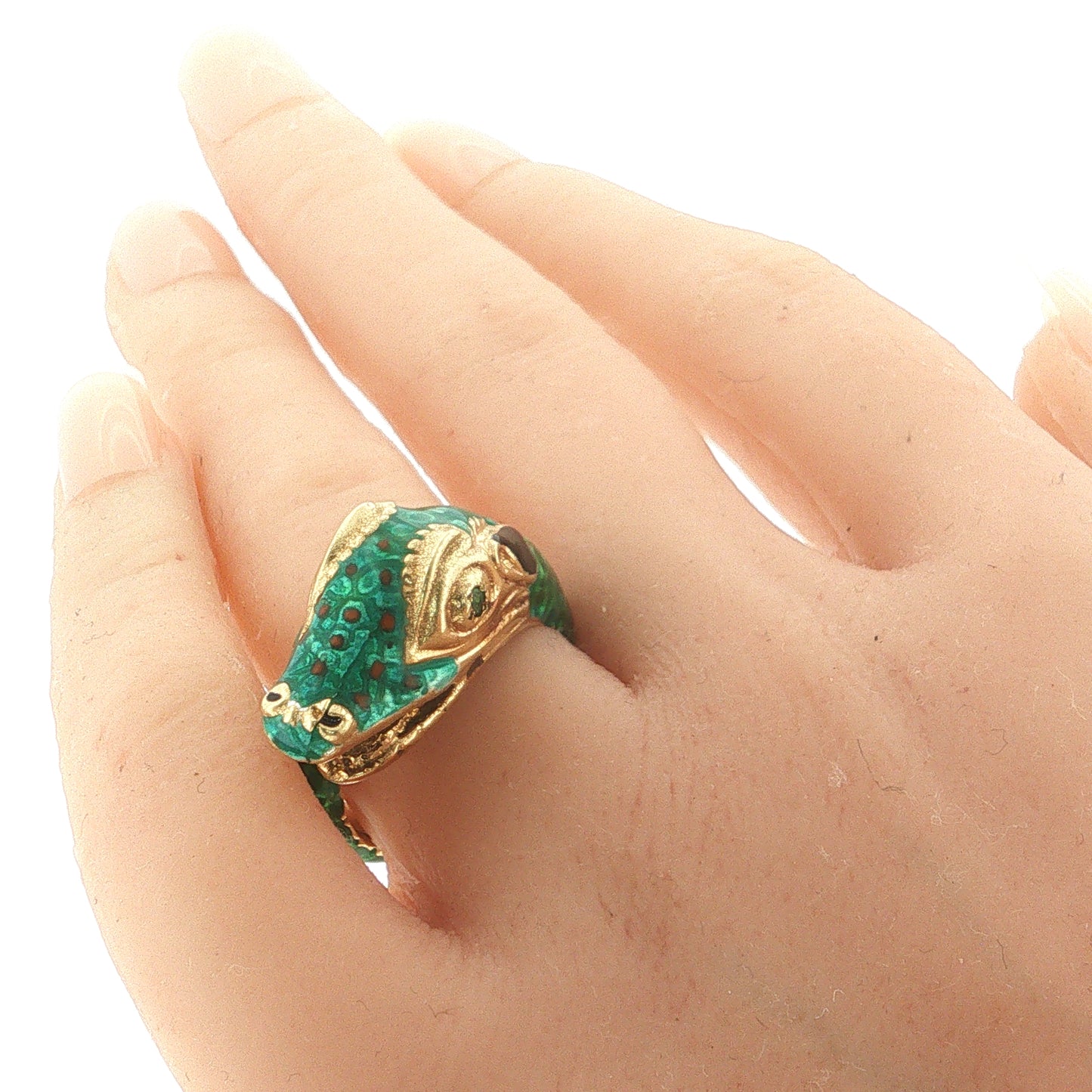 Green enamel snake statement ring crafted in 18k yellow gold with a natural emerald accent worn on the hand.