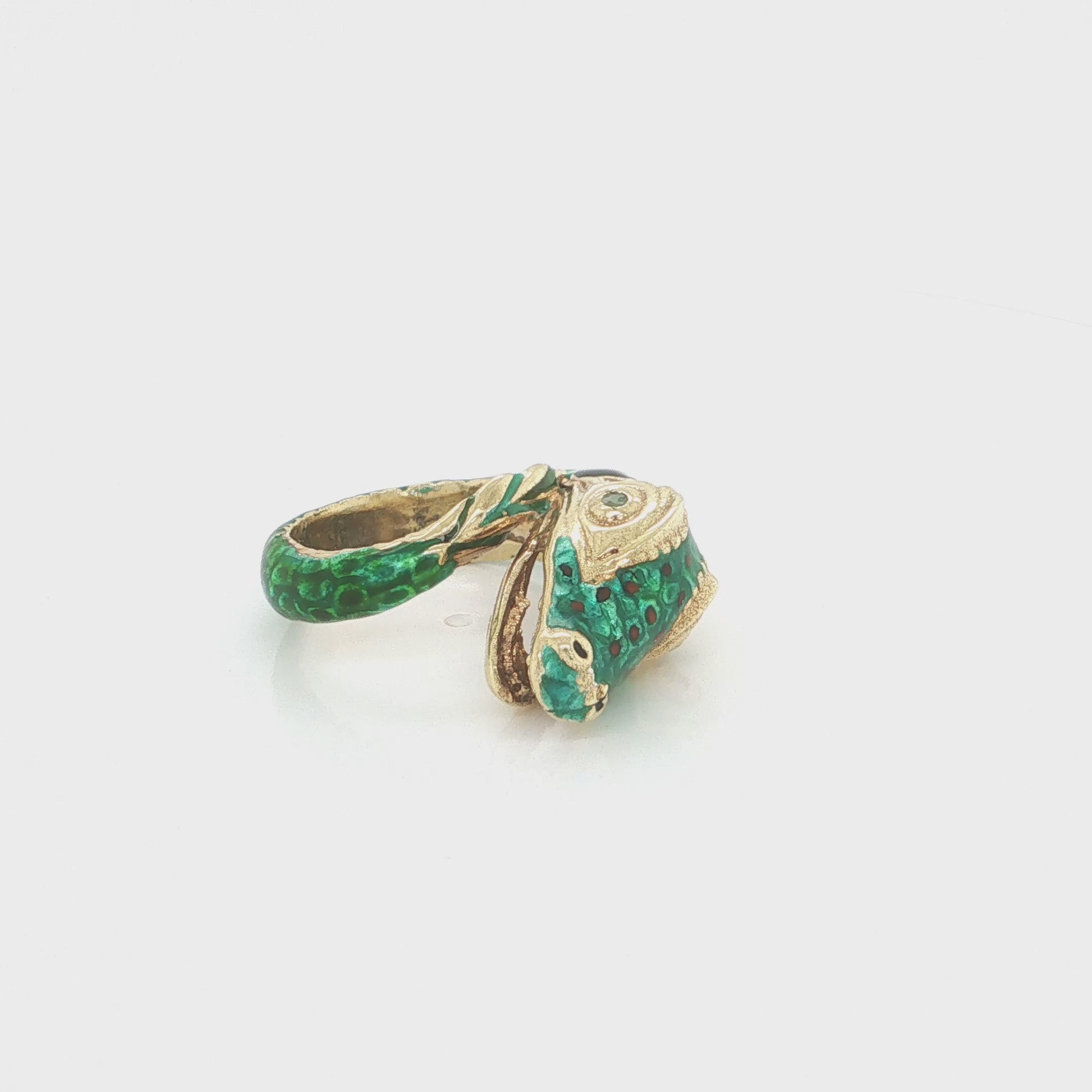 18k yellow gold snake statement ring with vibrant green enamel and a natural emerald accent.