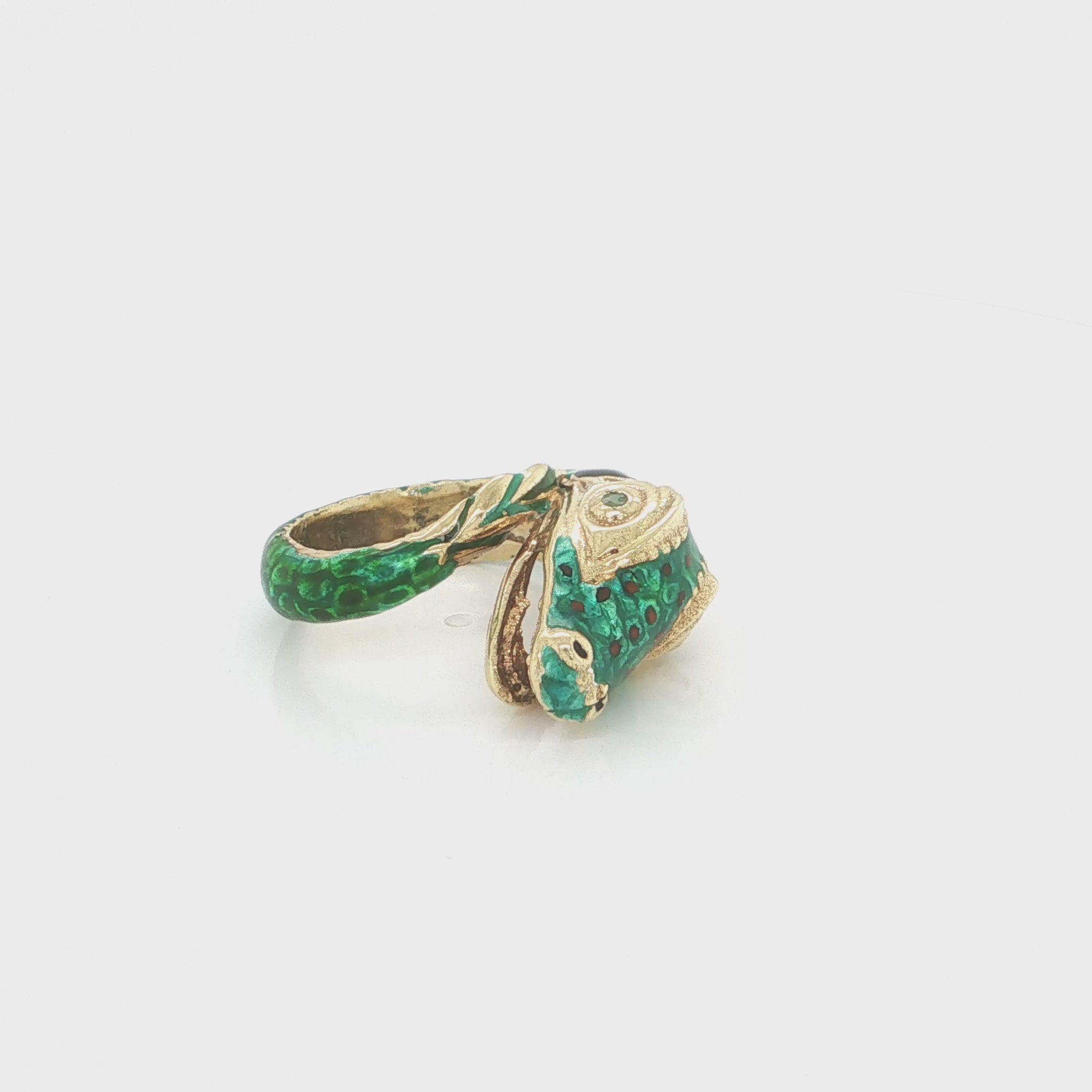 18k yellow gold snake statement ring with vibrant green enamel and a natural emerald accent.